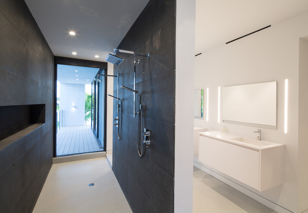 Immagine di un'ampia stanza da bagno design con ante lisce, ante bianche, doccia aperta, piastrelle nere, pareti bianche, lavabo sottopiano e doccia aperta