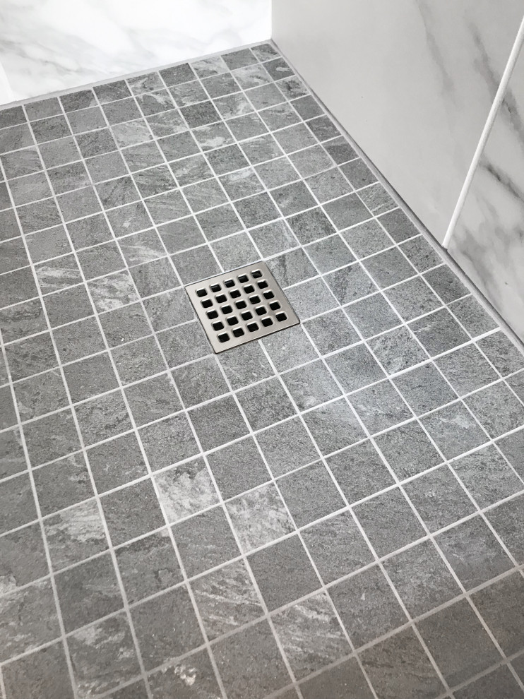 Пример оригинального дизайна: большая главная ванная комната в стиле модернизм с плоскими фасадами, белыми фасадами, отдельно стоящей ванной, душем в нише, унитазом-моноблоком, черно-белой плиткой, керамогранитной плиткой, серыми стенами, полом из керамогранита, врезной раковиной, столешницей из искусственного кварца, белым полом, душем с раздвижными дверями и белой столешницей