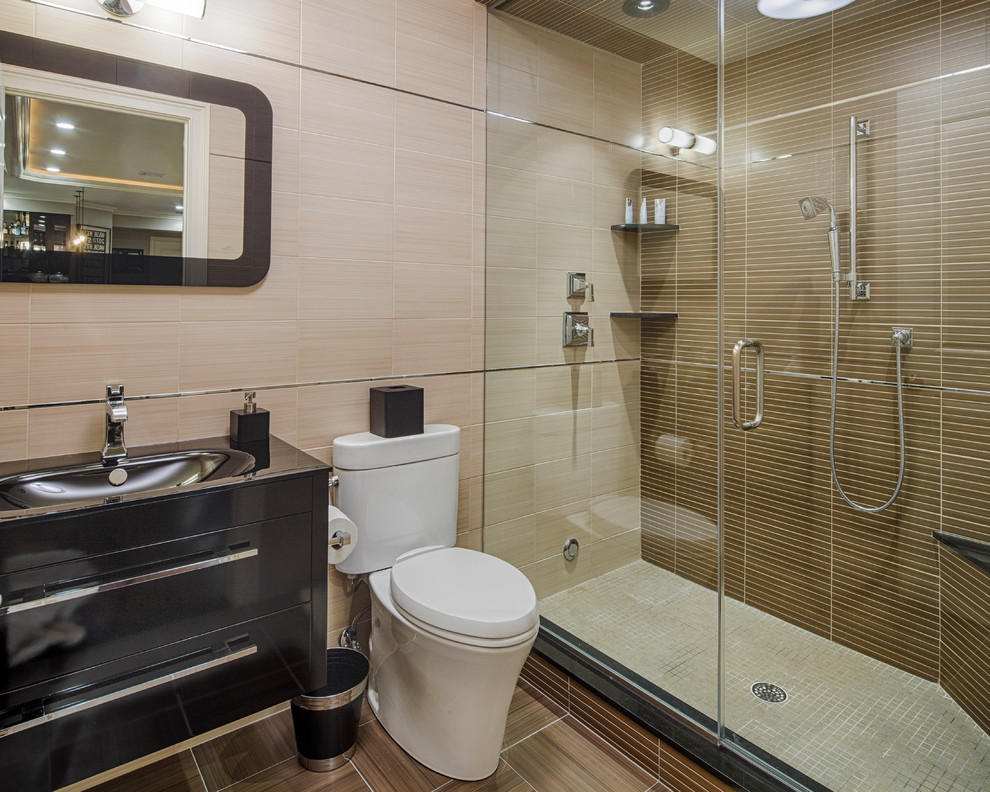 Идея дизайна: ванная комната среднего размера в современном стиле с монолитной раковиной, душем в нише, раздельным унитазом, плоскими фасадами, черными фасадами, коричневой плиткой, керамогранитной плиткой, полом из керамогранита, душевой кабиной, столешницей из искусственного камня, коричневым полом, душем с распашными дверями и черной столешницей