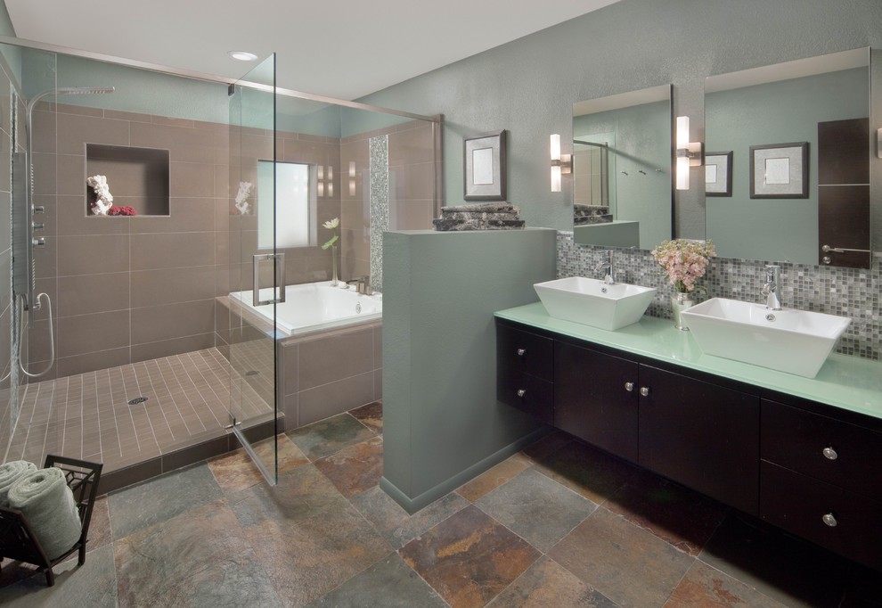 Идея дизайна: большая главная ванная комната в современном стиле с плоскими фасадами, темными деревянными фасадами, ванной в нише, душевой комнатой, раздельным унитазом, бежевой плиткой, серой плиткой, белой плиткой, плиткой мозаикой, серыми стенами, полом из сланца, настольной раковиной, стеклянной столешницей, разноцветным полом и душем с распашными дверями