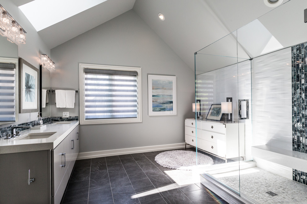 Inspiration for a large modern ensuite bathroom in Chicago with flat-panel cabinets, grey cabinets, a corner shower, a two-piece toilet, white tiles, porcelain tiles, grey walls, porcelain flooring, a submerged sink, engineered stone worktops, grey floors and a hinged door.
