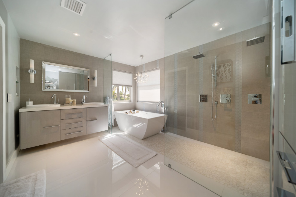На фото: большая главная ванная комната в стиле модернизм с плоскими фасадами, серыми фасадами, отдельно стоящей ванной, душем над ванной, унитазом-моноблоком, серой плиткой, керамогранитной плиткой, серыми стенами, полом из керамогранита, накладной раковиной, столешницей из кварцита, белым полом, открытым душем, белой столешницей, тумбой под две раковины и подвесной тумбой