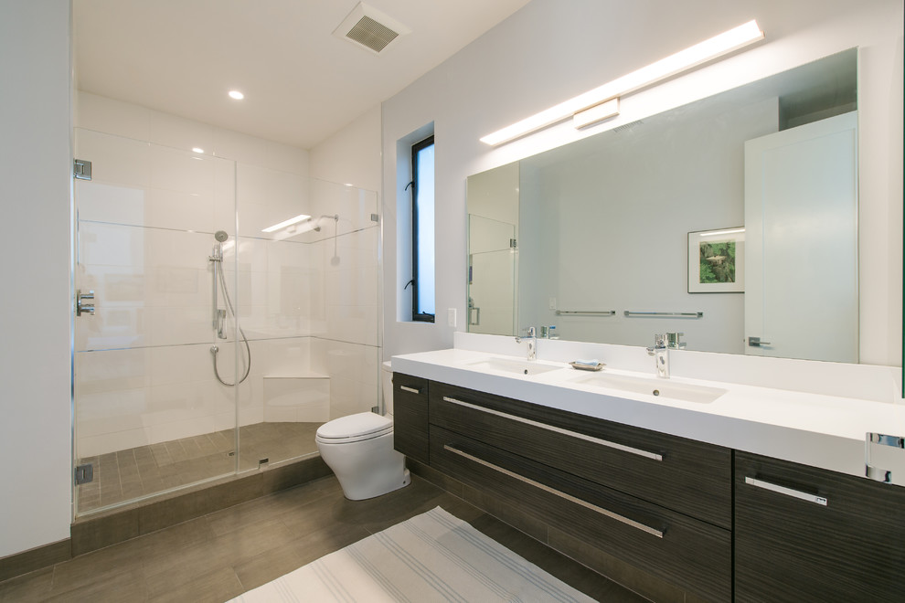Medium sized modern ensuite bathroom in Orange County with freestanding cabinets, dark wood cabinets, a corner shower, a two-piece toilet, white tiles, porcelain tiles, white walls, ceramic flooring, a submerged sink and wooden worktops.