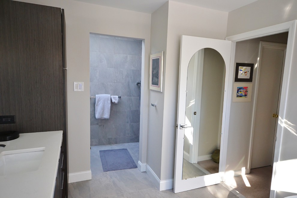 Large modern ensuite bathroom in Philadelphia with flat-panel cabinets, dark wood cabinets, a japanese bath, a double shower, a one-piece toilet, grey tiles, ceramic tiles, beige walls, ceramic flooring, a submerged sink, engineered stone worktops, beige floors and a sliding door.