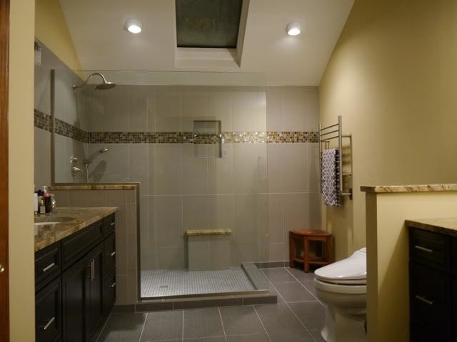 Inspiration for a medium sized modern shower room bathroom in New York with recessed-panel cabinets, black cabinets, a corner shower, a one-piece toilet, multi-coloured tiles, mosaic tiles, beige walls, laminate floors, a submerged sink, engineered stone worktops, grey floors and an open shower.