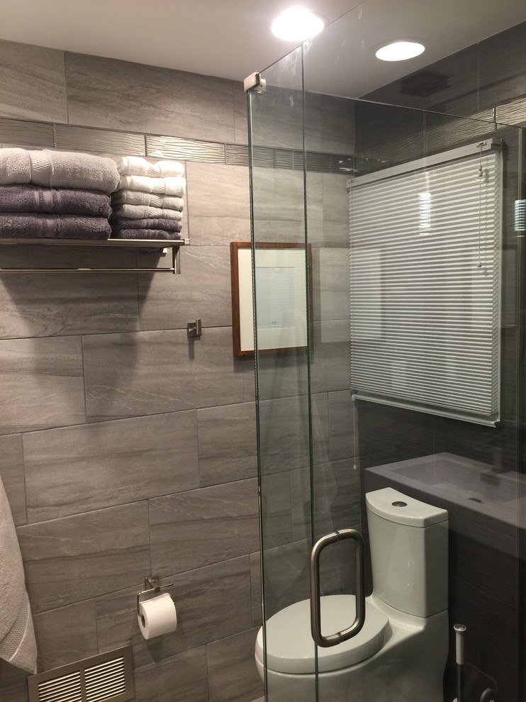 Inspiration för ett litet funkis en-suite badrum, med en hörndusch, en toalettstol med separat cisternkåpa, grå kakel, cementkakel, grå väggar, ett integrerad handfat och bänkskiva i akrylsten