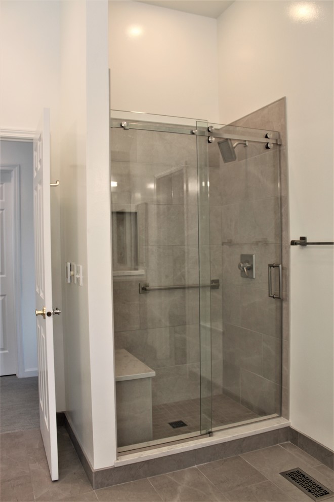 Réalisation d'une salle de bain principale minimaliste avec un placard à porte plane, des portes de placard grises, un carrelage gris, un lavabo encastré, un plan de toilette en quartz modifié, un sol gris et une cabine de douche à porte coulissante.