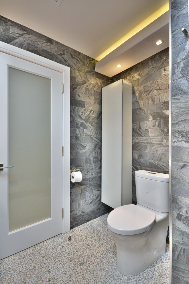 This is an example of a medium sized modern ensuite bathroom in New York with flat-panel cabinets, white cabinets, an alcove shower, a one-piece toilet, grey walls, pebble tile flooring, a submerged sink, white floors, a hinged door, grey tiles, engineered stone worktops and marble tiles.