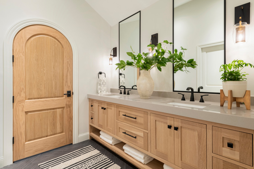 На фото: ванная комната в стиле модернизм с светлыми деревянными фасадами, серым полом, бежевой столешницей, сиденьем для душа, тумбой под две раковины и сводчатым потолком