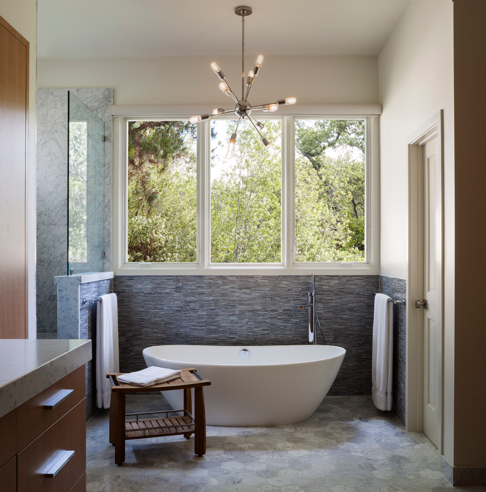 Inspiration för ett stort funkis en-suite badrum, med ett undermonterad handfat, släta luckor, skåp i ljust trä, marmorbänkskiva, ett fristående badkar, en dusch i en alkov, blå kakel, glaskakel, marmorgolv och beige väggar