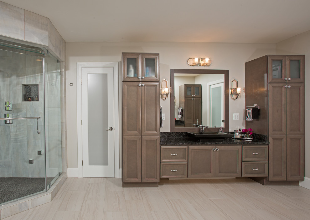 Cette image montre une grande salle de bain principale minimaliste avec des portes de placard marrons, un plan de toilette en granite et un sol gris.