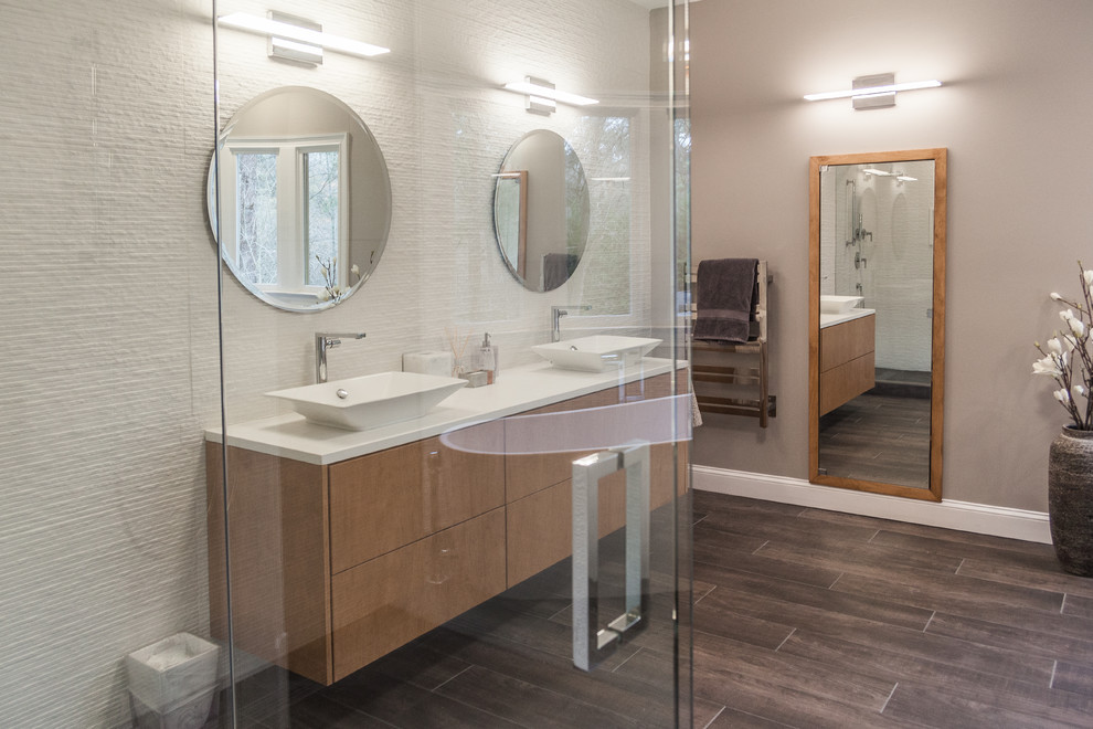 Inspiration for a large modern ensuite bathroom in Atlanta with flat-panel cabinets, light wood cabinets, a freestanding bath, a one-piece toilet, white tiles, porcelain tiles, grey walls, porcelain flooring, a vessel sink, quartz worktops, grey floors, a hinged door and white worktops.