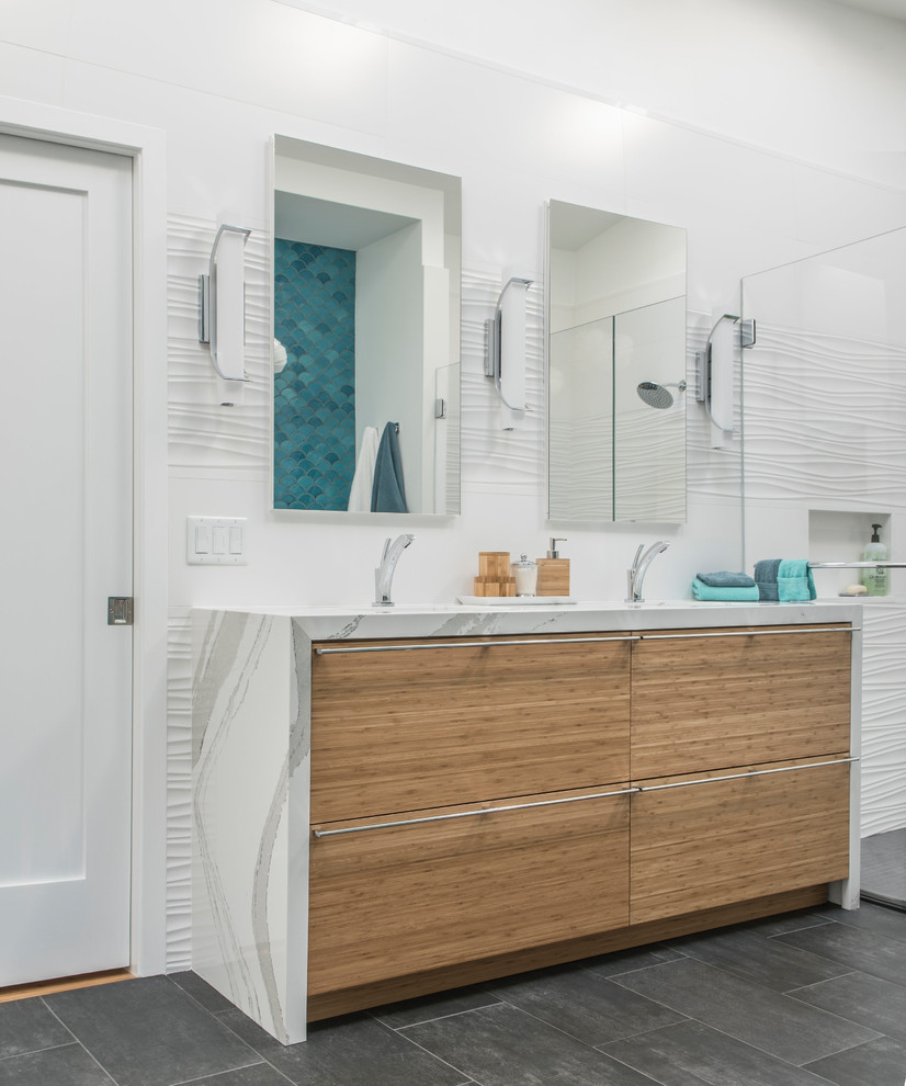 Inspiration for a large eclectic ensuite bathroom in Boston with flat-panel cabinets, light wood cabinets, a freestanding bath, a built-in shower, a one-piece toilet, white tiles, porcelain tiles, white walls, porcelain flooring, a submerged sink, solid surface worktops, grey floors and a hinged door.