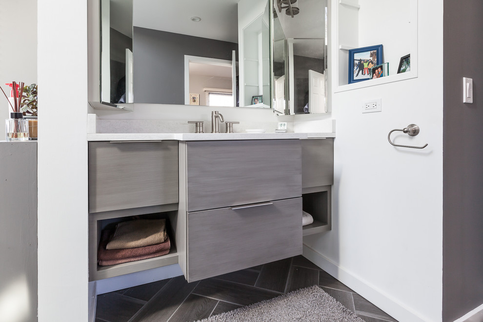 This is an example of a large modern ensuite bathroom in Chicago with flat-panel cabinets, grey cabinets, a freestanding bath, a corner shower, engineered stone worktops and grey floors.
