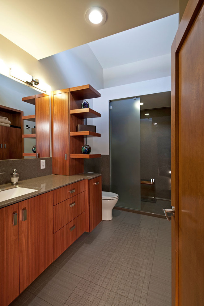 Inredning av ett modernt mellanstort en-suite badrum, med släta luckor, skåp i mellenmörkt trä, en öppen dusch, en toalettstol med hel cisternkåpa, grå kakel, keramikplattor, vita väggar, klinkergolv i porslin, ett integrerad handfat och bänkskiva i onyx