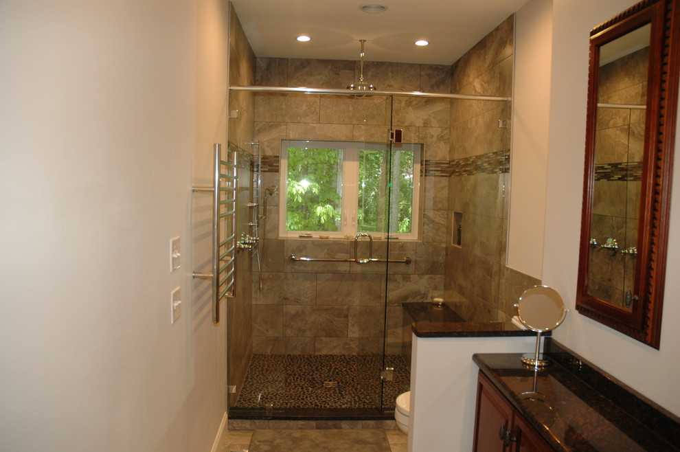 Inredning av ett modernt en-suite badrum, med luckor med upphöjd panel, skåp i mellenmörkt trä, granitbänkskiva, en bidé, grå kakel, porslinskakel, grå väggar och klinkergolv i porslin