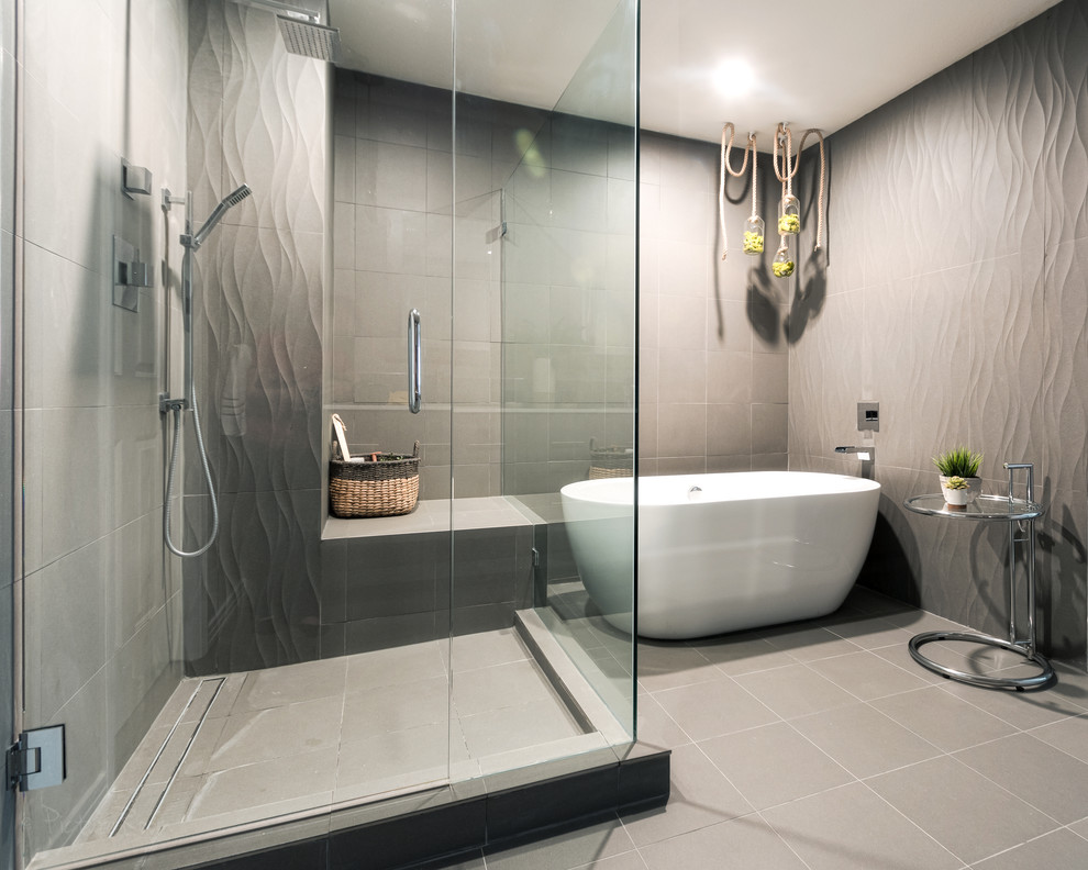 Idéer för mellanstora funkis en-suite badrum, med ett fristående badkar, grå kakel, stenkakel, grå väggar, en hörndusch, grått golv och dusch med gångjärnsdörr