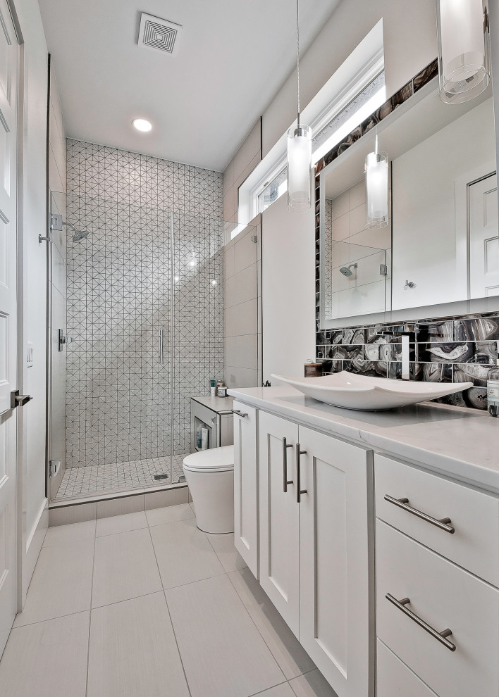 Mid-sized minimalist kids' gray tile and porcelain tile porcelain tile, gray floor and single-sink bathroom photo in Other with flat-panel cabinets, white cabinets, a one-piece toilet, white walls, a trough sink, quartzite countertops, a hinged shower door, gray countertops and a built-in vanity
