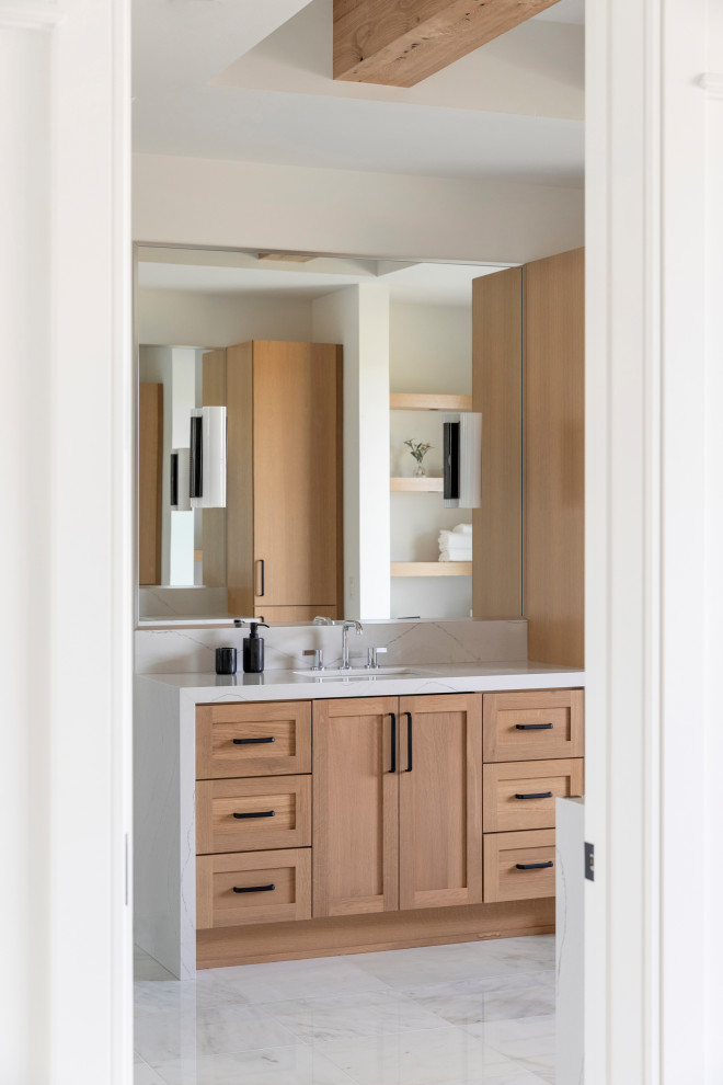 Inspiration for a country master marble floor, white floor, double-sink and exposed beam bathroom remodel in Minneapolis with flat-panel cabinets, light wood cabinets, white walls, an undermount sink, quartz countertops, a hinged shower door, white countertops and a built-in vanity