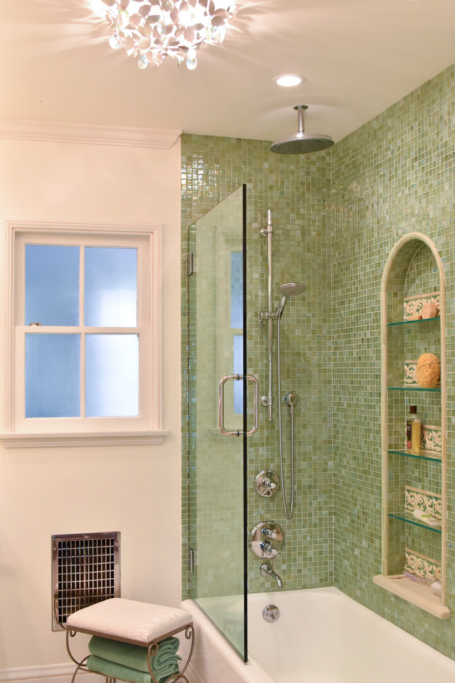На фото: большая главная ванная комната в средиземноморском стиле с врезной раковиной, фасадами с утопленной филенкой, искусственно-состаренными фасадами, столешницей из искусственного камня, угловой ванной, душем над ванной, унитазом-моноблоком, зеленой плиткой, стеклянной плиткой, бежевыми стенами и полом из керамогранита