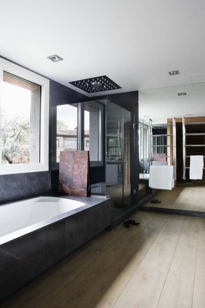 Ejemplo de cuarto de baño contemporáneo con bañera encastrada sin remate, ducha empotrada, baldosas y/o azulejos negros y losas de piedra