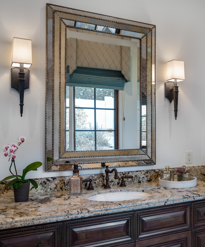 Example of a large classic master porcelain tile travertine floor bathroom design in Phoenix with a drop-in sink, beaded inset cabinets, dark wood cabinets, granite countertops, a one-piece toilet and gray walls