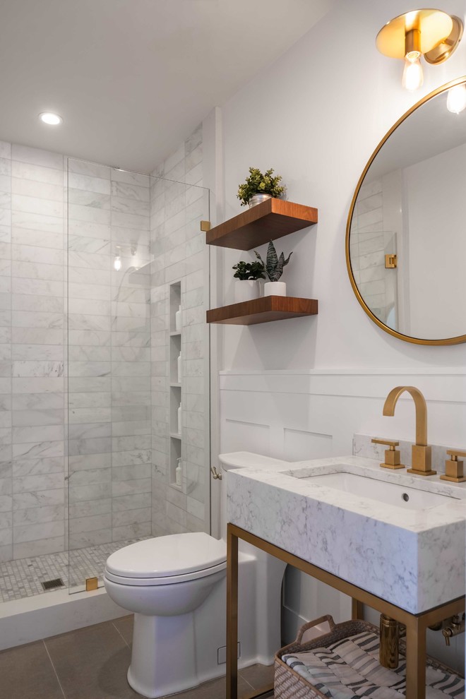 Inspiration för små moderna vitt badrum med dusch, med en dusch i en alkov, en toalettstol med hel cisternkåpa, vit kakel, marmorkakel, vita väggar, marmorbänkskiva, dusch med gångjärnsdörr, öppna hyllor, vita skåp, klinkergolv i porslin, ett konsol handfat och brunt golv