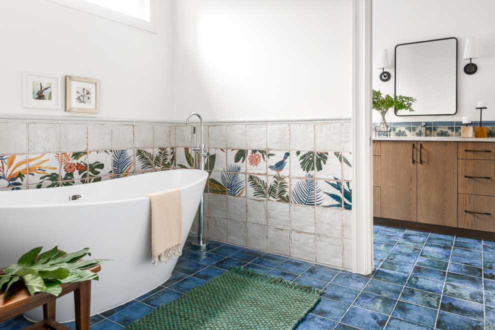 Cette image montre une salle de bain principale bohème en bois brun de taille moyenne avec un placard à porte plane, une baignoire indépendante, un carrelage multicolore, des carreaux de céramique, un mur blanc, un lavabo posé, un plan de toilette en quartz, un sol bleu, un plan de toilette beige, meuble double vasque et meuble-lavabo encastré.