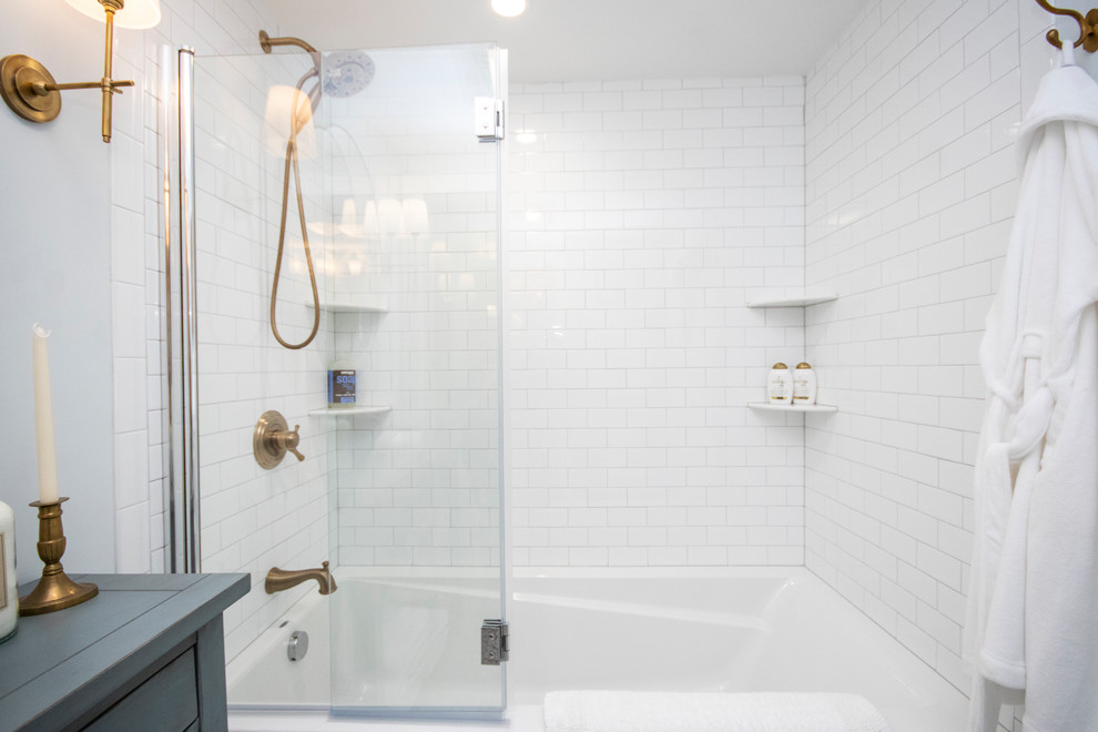 Photo of a medium sized traditional ensuite bathroom in Providence with recessed-panel cabinets, white cabinets, a built-in bath, a shower/bath combination, a one-piece toilet, white tiles, metro tiles, blue walls, porcelain flooring, a submerged sink, granite worktops, white floors, a hinged door and white worktops.