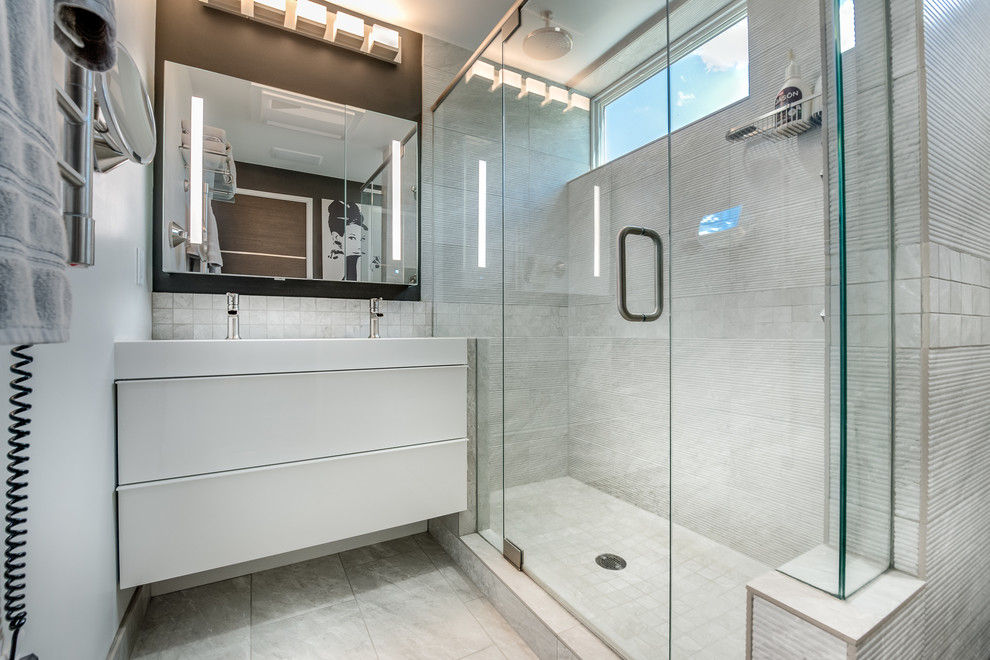 Exempel på ett litet modernt badrum med dusch, med släta luckor, vita skåp, vit kakel, vita väggar, en dubbeldusch, ett avlångt handfat och bänkskiva i akrylsten