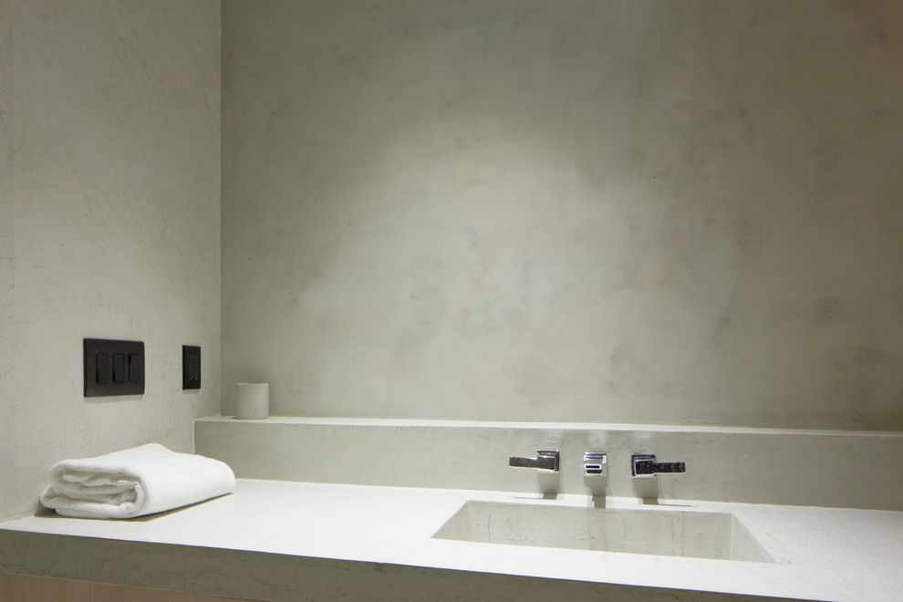 Cette photo montre une salle de bain tendance avec un lavabo intégré et un plan de toilette en béton.
