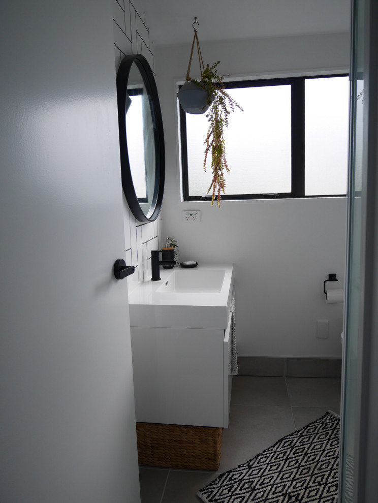 Идея дизайна: маленькая ванная комната в стиле ретро с белыми фасадами, угловым душем, белой плиткой, керамической плиткой, полом из цементной плитки, душевой кабиной, столешницей из искусственного кварца, серым полом, душем с распашными дверями, белой столешницей, тумбой под одну раковину и подвесной тумбой для на участке и в саду
