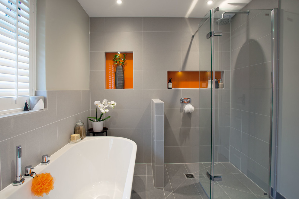 Foto på ett mellanstort funkis badrum med dusch, med våtrum, keramikplattor, grå väggar, klinkergolv i keramik, grått golv, dusch med gångjärnsdörr, ett fristående badkar och grå kakel