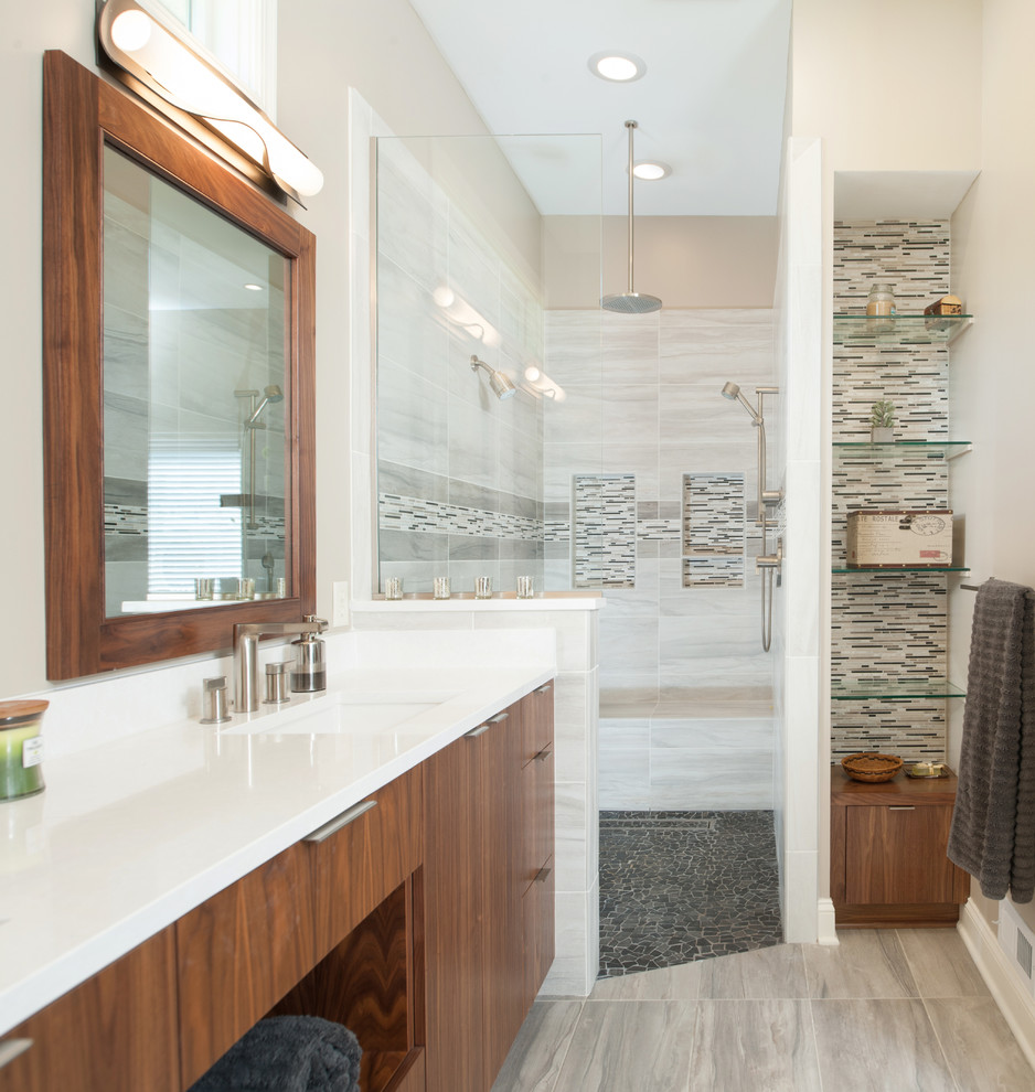 Inspiration for a large contemporary ensuite bathroom in Kansas City with flat-panel cabinets, medium wood cabinets, engineered stone worktops, an alcove shower, grey tiles, ceramic tiles, beige walls, ceramic flooring, a freestanding bath and an integrated sink.