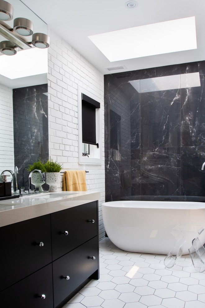 Modernes Badezimmer mit flächenbündigen Schrankfronten, schwarzen Schränken, freistehender Badewanne, schwarzen Fliesen, weißer Wandfarbe, Unterbauwaschbecken, weißem Boden, beiger Waschtischplatte, Doppelwaschbecken, eingebautem Waschtisch und Ziegelwänden in Toronto