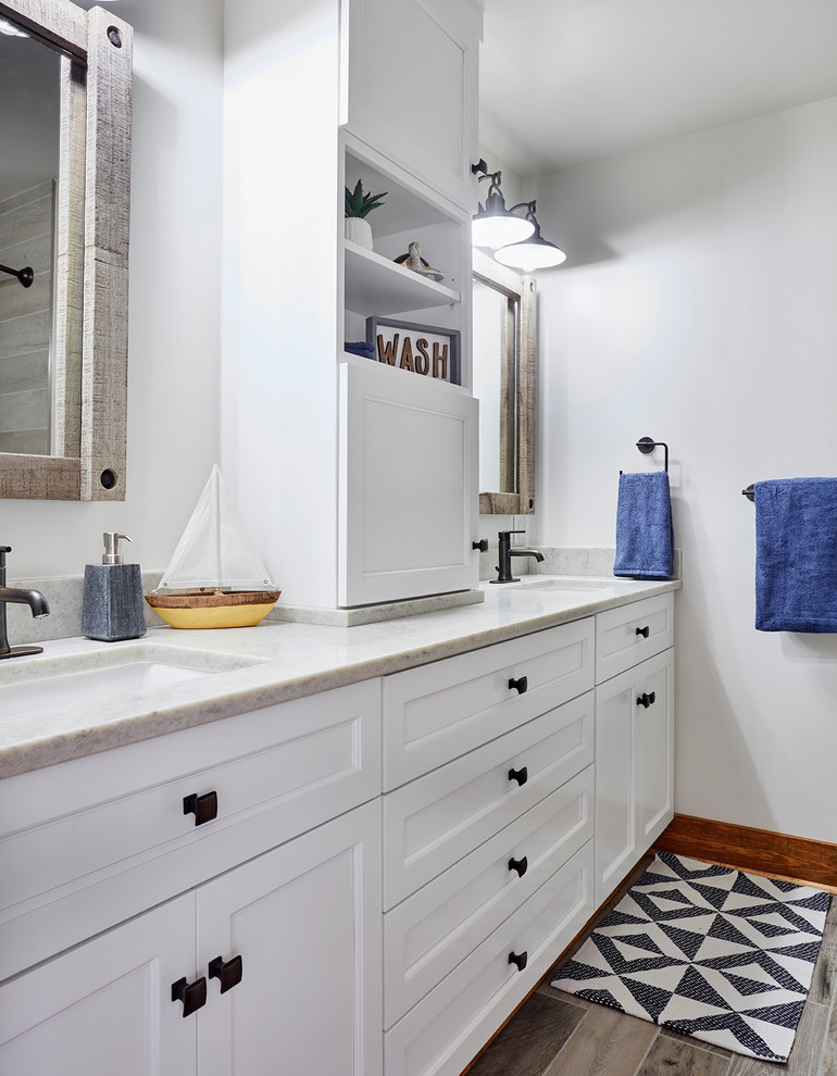 Example of a small mountain style kids' porcelain tile and brown floor bathroom design in Richmond with recessed-panel cabinets, white cabinets, a two-piece toilet, white walls, an undermount sink, quartz countertops and white countertops