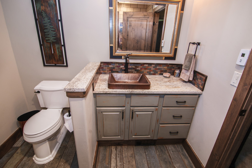 Idée de décoration pour une salle de bain minimaliste en bois vieilli de taille moyenne avec un plan de toilette beige, un placard avec porte à panneau surélevé, une baignoire encastrée, WC séparés, un carrelage blanc, un carrelage métro, un mur beige, parquet foncé, une vasque, un plan de toilette en granite et un sol marron.