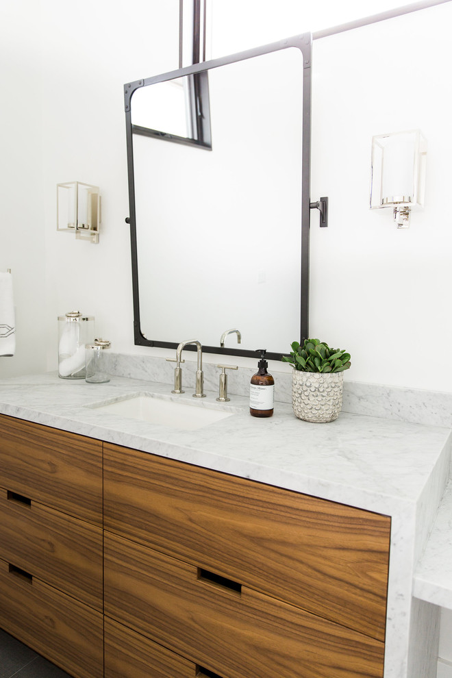 Traditional bathroom in Salt Lake City with flat-panel cabinets, medium wood cabinets, white walls, a built-in sink and marble worktops.