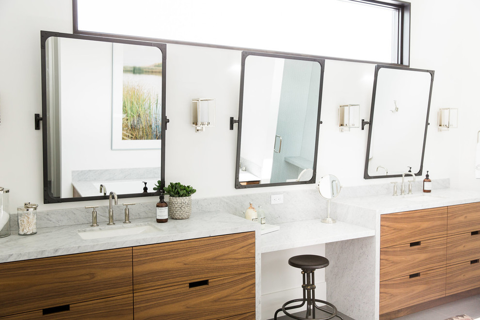 Foto de cuarto de baño clásico renovado con armarios con paneles lisos, puertas de armario de madera oscura, encimera de mármol, paredes blancas, lavabo bajoencimera y espejo con luz