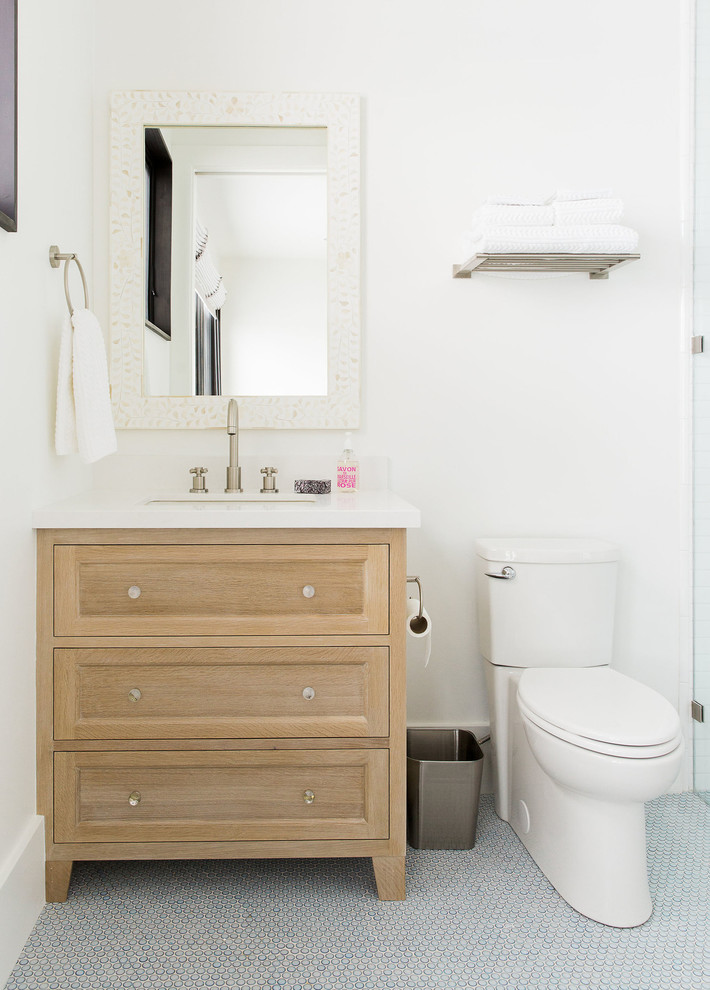 Diseño de cuarto de baño tradicional renovado con armarios con paneles lisos, puertas de armario de madera clara y paredes blancas
