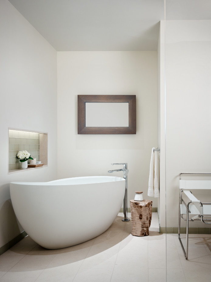 Diseño de cuarto de baño principal actual grande con bañera exenta, paredes blancas, suelo de cemento y suelo blanco