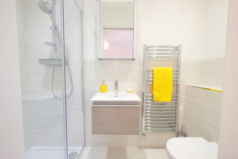 Cette image montre une petite salle de bain principale minimaliste avec une douche double, WC suspendus, des carreaux de porcelaine, un mur beige, un sol en carrelage de porcelaine, un lavabo suspendu, un sol blanc et une cabine de douche à porte battante.