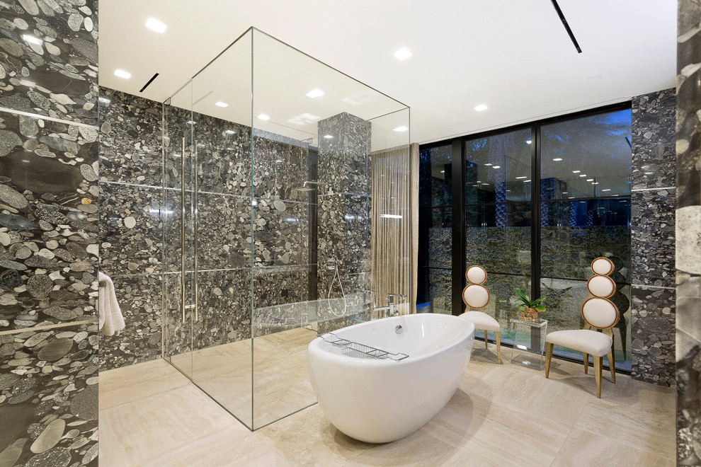 Modern inredning av ett badrum, med ett fristående badkar, en hörndusch, svart och vit kakel, grå kakel, stenhäll, grå väggar, beiget golv och dusch med gångjärnsdörr