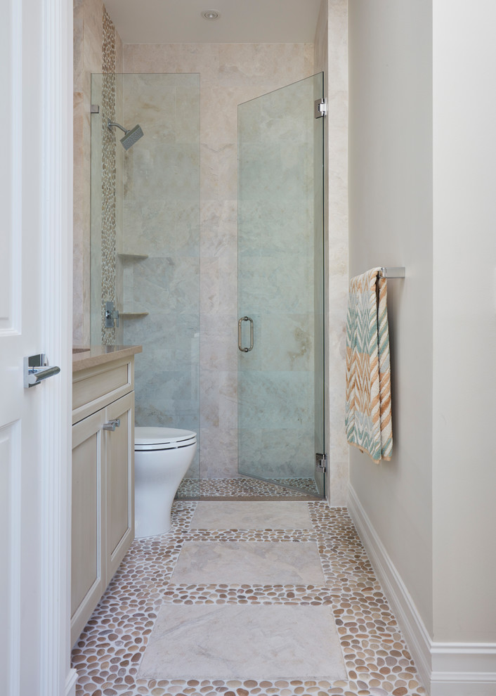 Photo of a small modern shower room bathroom in Miami with beaded cabinets, beige cabinets, a built-in shower, a one-piece toilet, beige tiles, porcelain tiles, beige walls, a submerged sink, engineered stone worktops, a hinged door, pebble tile flooring and beige floors.