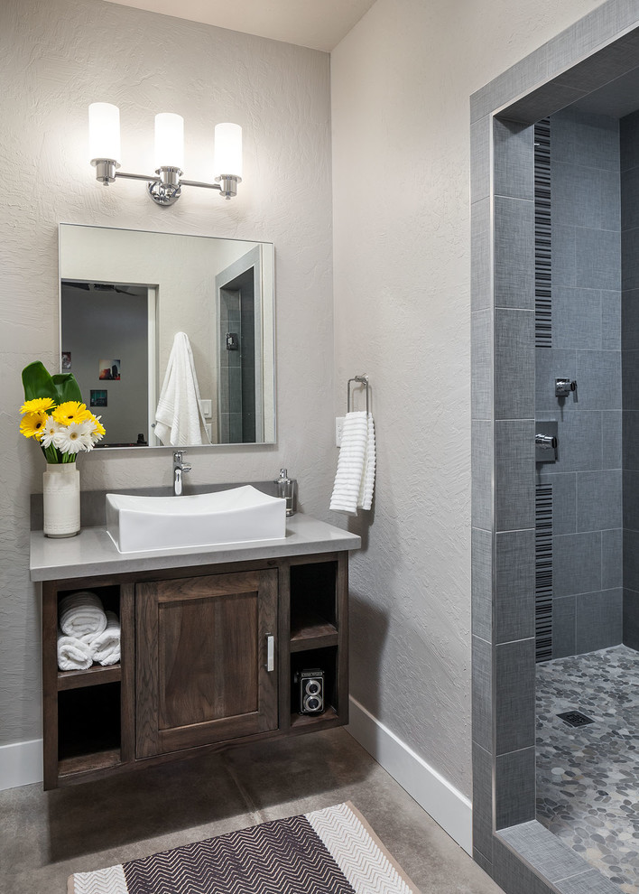 Foto på ett mellanstort funkis badrum, med ett fristående handfat, skåp i shakerstil, skåp i mörkt trä, bänkskiva i kvarts, en dusch i en alkov, grå kakel, porslinskakel, grå väggar och betonggolv
