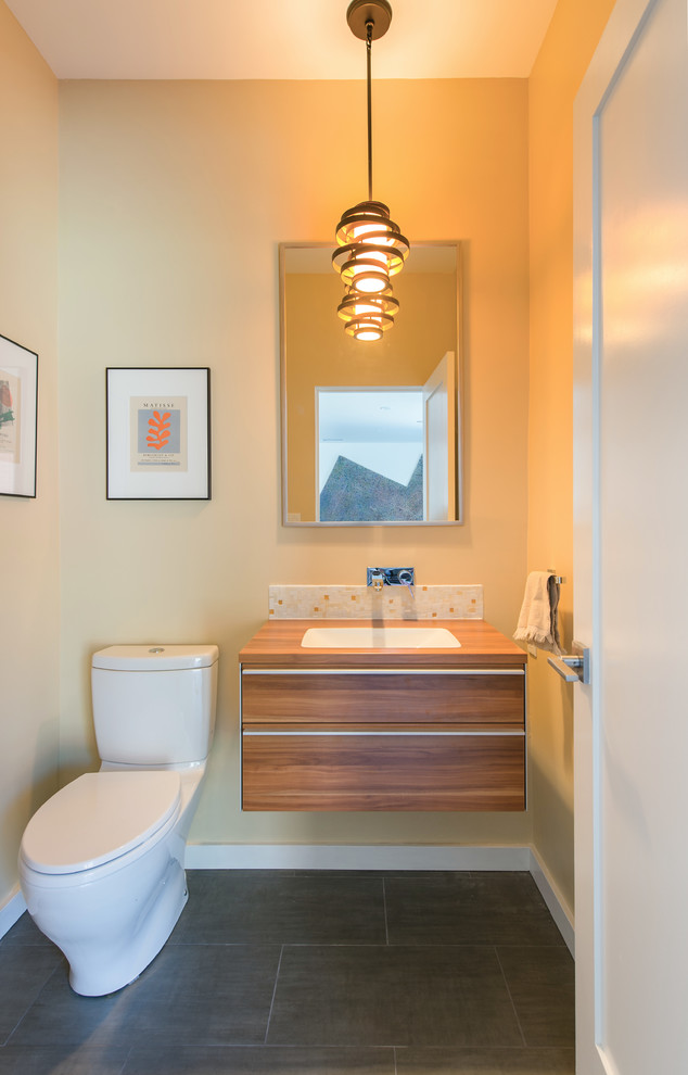 This is an example of a small modern shower room bathroom in Orange County with freestanding cabinets, medium wood cabinets, a two-piece toilet, ceramic flooring, an integrated sink, wooden worktops, multi-coloured tiles, mosaic tiles and beige walls.