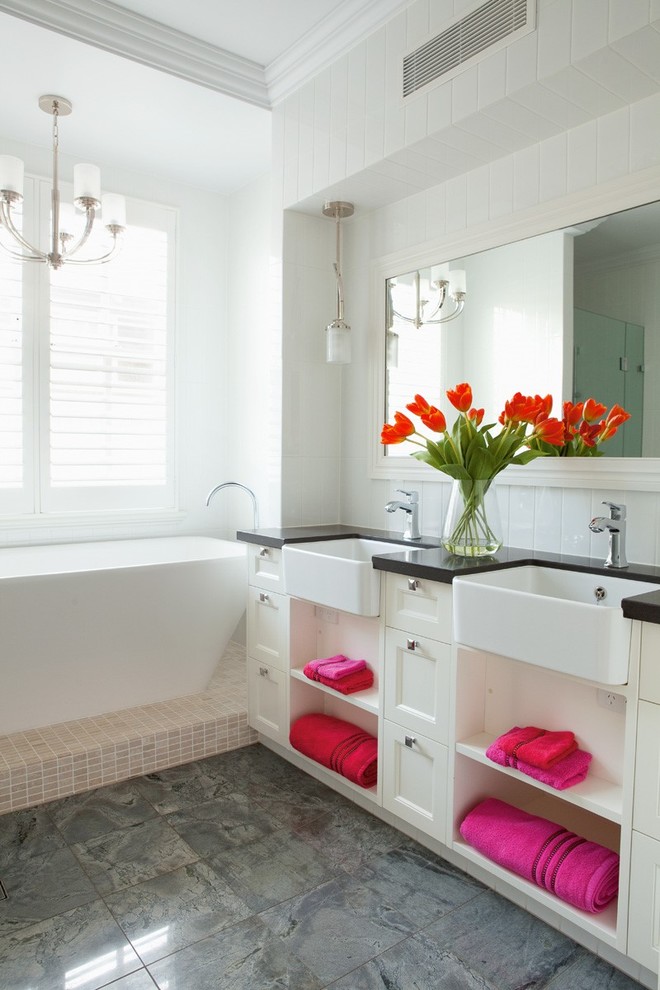 Imagen de cuarto de baño tradicional renovado de tamaño medio con armarios con paneles empotrados, puertas de armario blancas, encimera de cuarzo compacto, bañera empotrada, baldosas y/o azulejos grises y paredes blancas