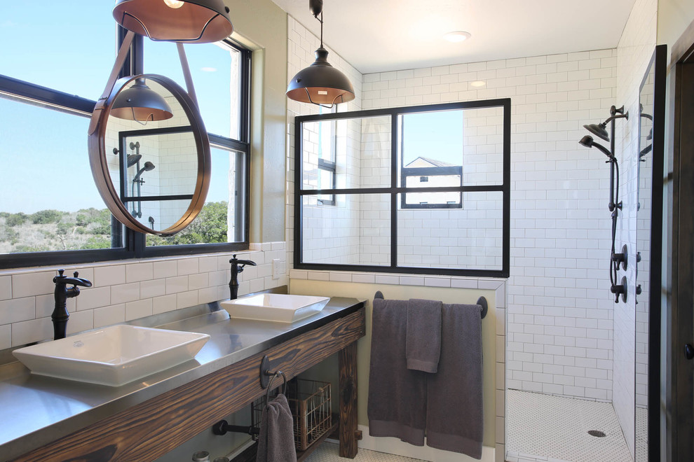 Cette photo montre une salle de bain nature avec un carrelage blanc, un mur blanc, une vasque, un plan de toilette en acier inoxydable et une cabine de douche à porte battante.