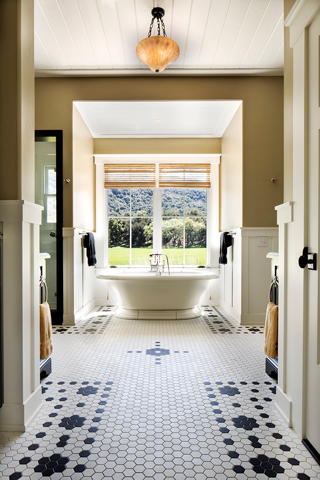 Imagen de cuarto de baño principal de estilo de casa de campo grande con bañera exenta, baldosas y/o azulejos blancas y negros, paredes beige y suelo de baldosas de cerámica