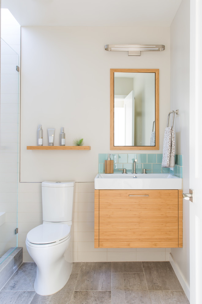 Пример оригинального дизайна: ванная комната среднего размера в современном стиле с плоскими фасадами, белой плиткой, консольной раковиной, серым полом, светлыми деревянными фасадами, душем в нише, унитазом-моноблоком, бежевыми стенами, полом из керамогранита и душевой кабиной
